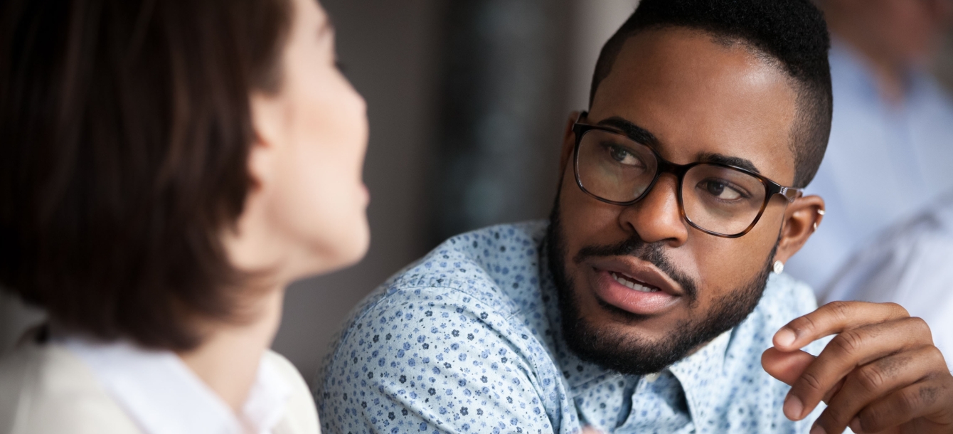 Young man speaking with female colleague