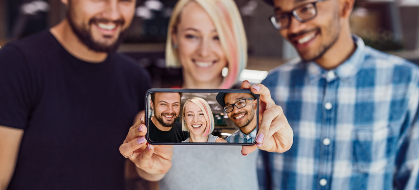 Three friends showing the camera their selfie